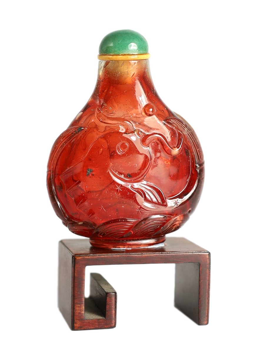 A Chinese ruby red glass ‘leaping carp’ snuff bottle, 1750-1850, 5.9cm high